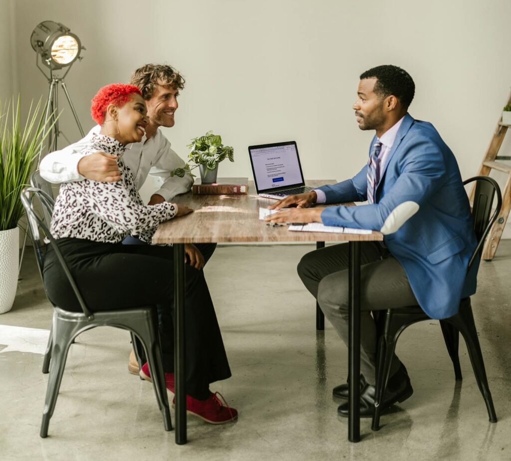 A professional financial advisor discusses options with a couple in a modern office setting.